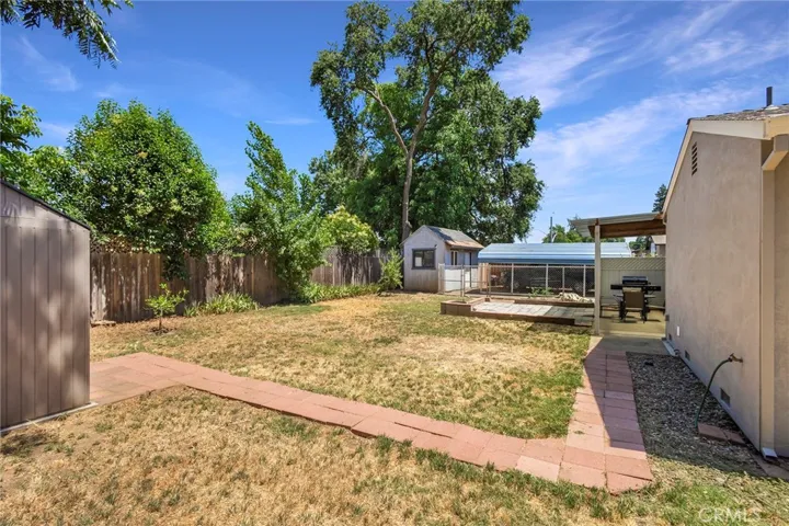 Backyard Shot of Very Sturdy Stucco and Brick Construction with At active Wisteria Vines located on a large quarter acre, mostly fenced-in lot. 1532 Sqft 3/2 hom is also commercially zoned to run your own business from home!