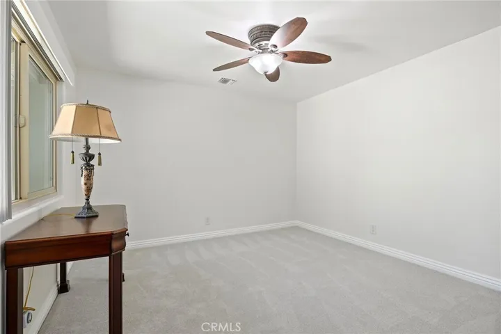 Ceiling fan and mirrored closet doors in secondary bedroom