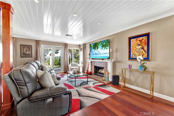 Beyond the entryway, the open dining and living room feature a cozy fireplace