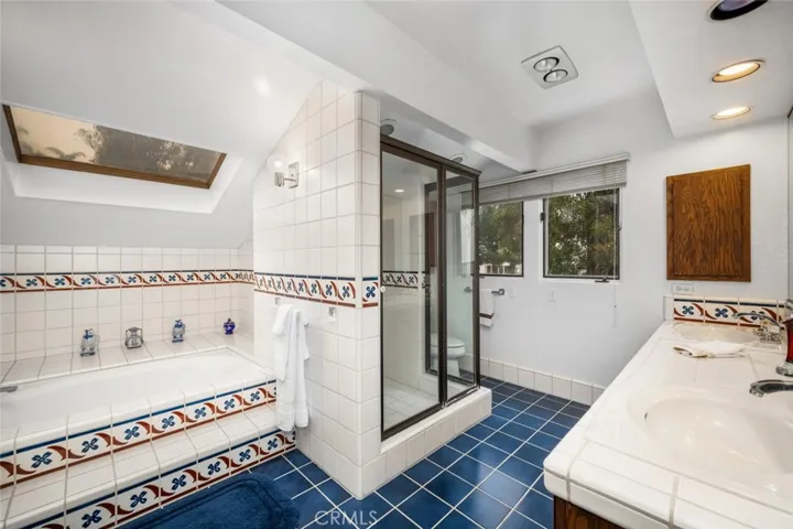 Primary ensuite bathroom with large bathtub, walk in shower and walk in closet attached