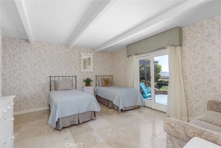 The very bright and light, spacious, lower level suite could be primary if looking someone is to stay on the ground floor! With a beautiful adjoining bathroom and door to the sanctuary garden area. Easy access to outside patio and beautiful blue water views.