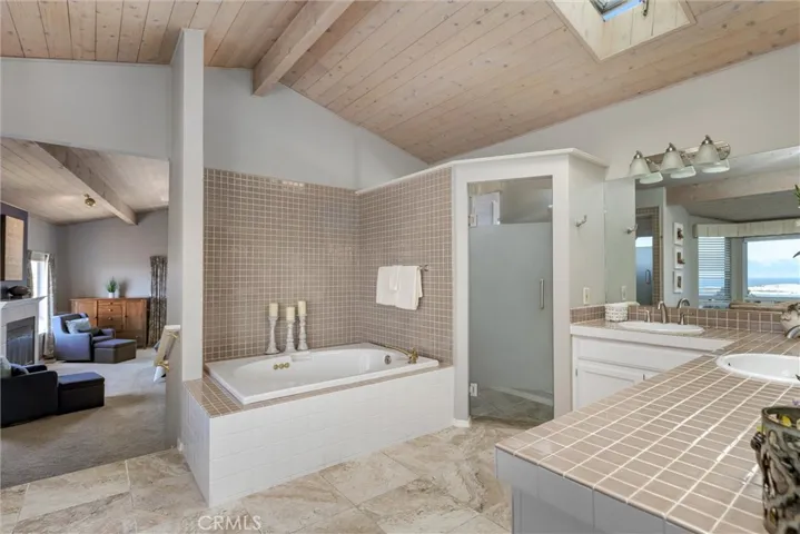 Upper level primary suite bathroom hosts a spa tub, private water closet, two sinks, walk-in shower and a relaxation alcove to unwind and watch the water.