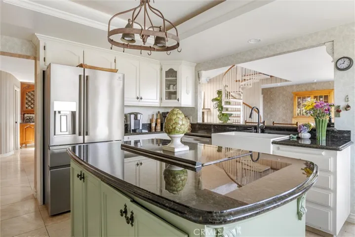 Kitchen complete with granite countertops, bar top and seating, stainless appliances, farmhouse sink, walk-in pantry and custom cabinets.