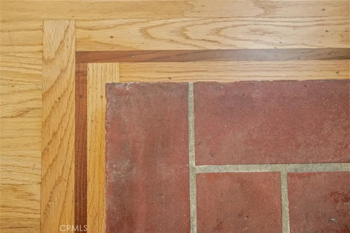 Contrasting wood trim at brick hearth.