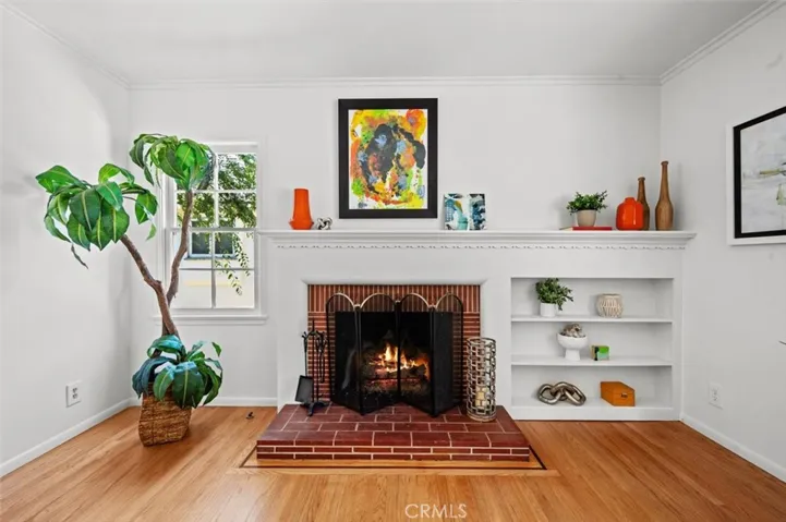 A brick wood burning fireplace with shelves and curvey mantle.