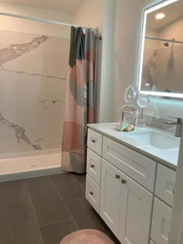 Remodel of the bathroom boasts a large shower stall in fine finishes