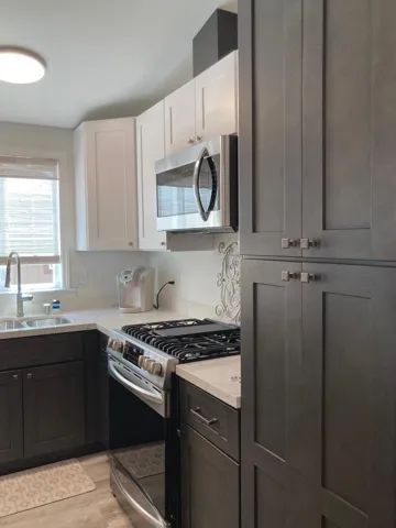 All new - two tone cabinets, appliances (gas 5 burner stove), quartz countertop, pull out trash