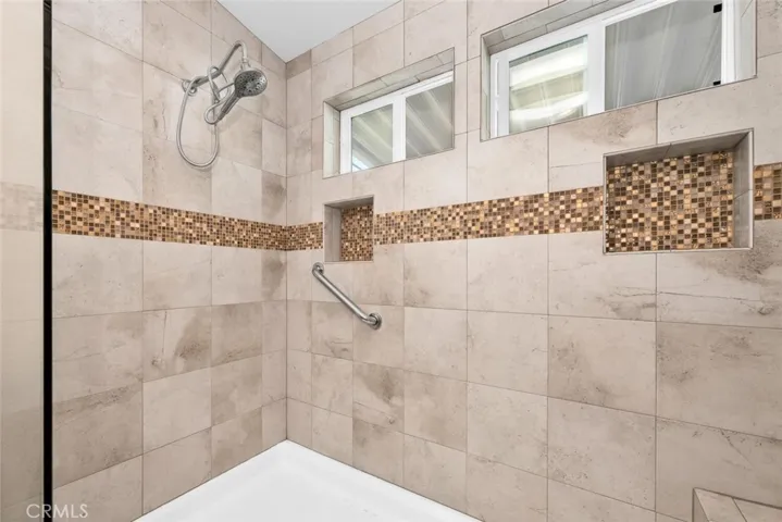 Master bath shower offers safety grab bar and built-in bench seating.