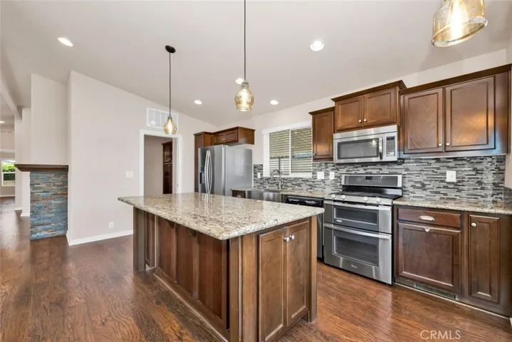 Modern kitchen features kitchen island with granite countertops and plenty of storage below.
