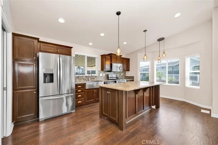Other kitchen features include recessed and pendulum lighting, mosaic backsplash and stainless farm sink.