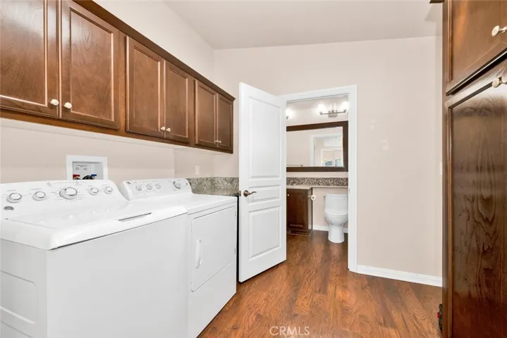 Inside laundry room with overhead storage and additional cabinets that could be used as a food storage pantry.