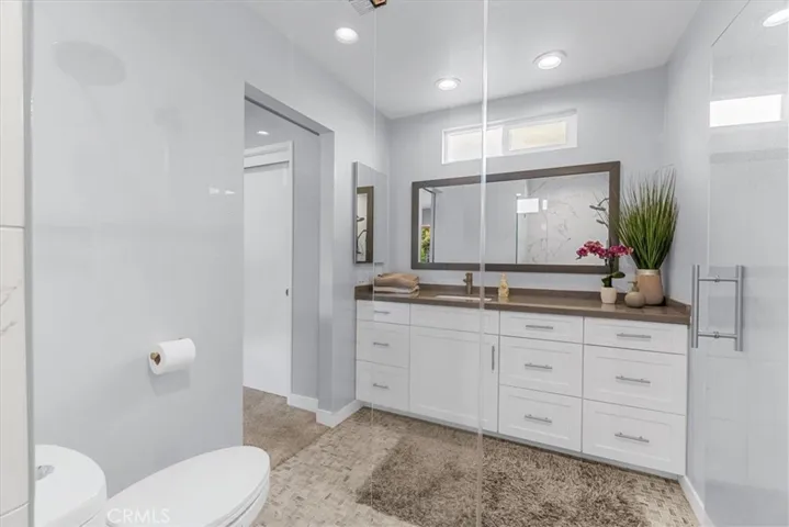 Basketweave stone tile floor and newer vanity with slab and under mount sink.