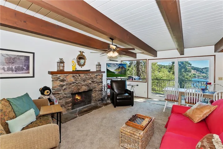 Main level living room with cozy fireplace and sliding glass door to decking