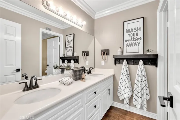 Bath 3 is located upstairs between the secondary bedrooms and includes dual vanities.