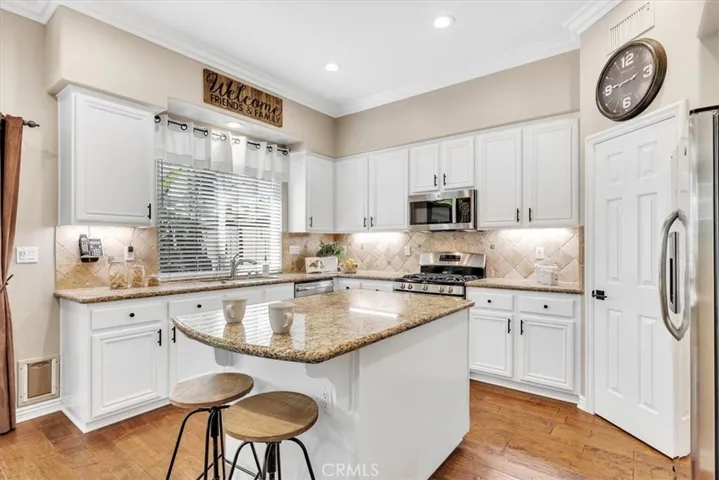 The upgraded kitchen is a chef's dream with 5 burner gas range, large pantry, and a spacious island with counter seating.