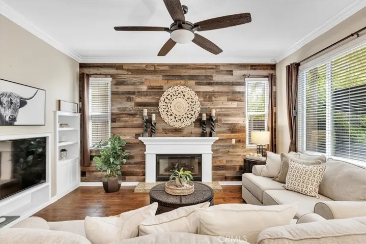 The Family-Favorite Hangout Spot includes freshly painted crown molding & baseboards, designer ceiling fan, hardwood flooring, large picture window overlooking the back patio.