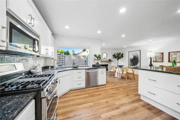 The kitchen is conveniently off the dining room & boasts fresh, white cabinetry, ample storage