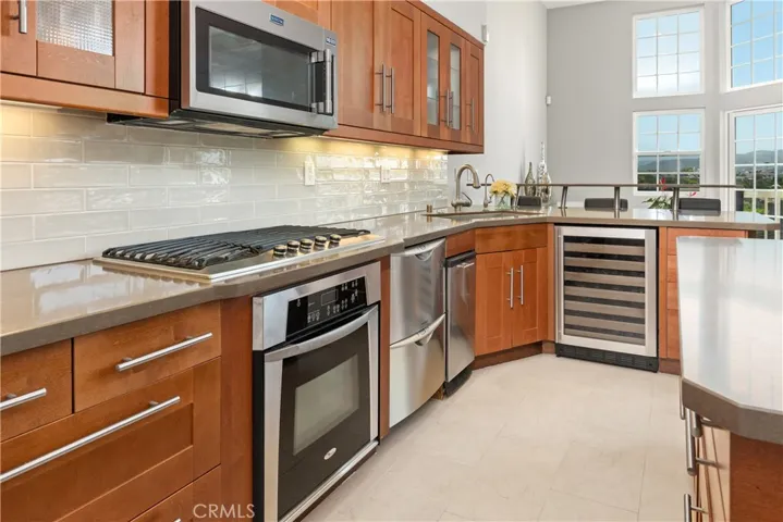 Kitchen has wine fridge and 5 burner stove