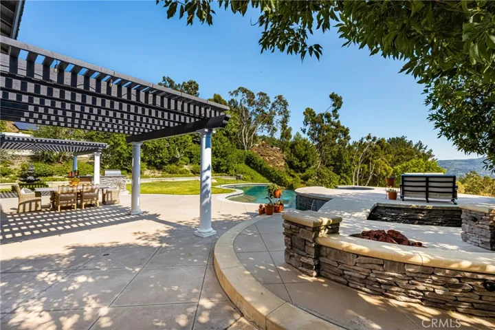 The patio features two covered porches, built-in kitchen, fountain and large grass area.