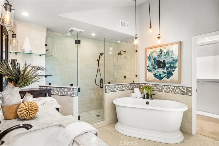 Recently remodeled primary bath features an oversized walk-in shower, double sinks and a free-standing tub.