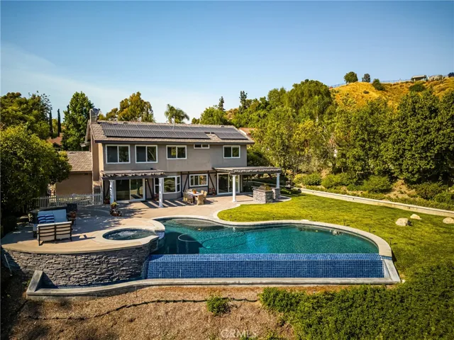 A reverse view towards the house shows the waterfall edge ofr the infinity pool and large grassy area.