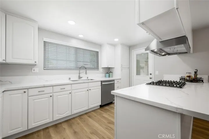Upgraded kitchen features quartz countertops, stainless steel sink, and recessed lights.