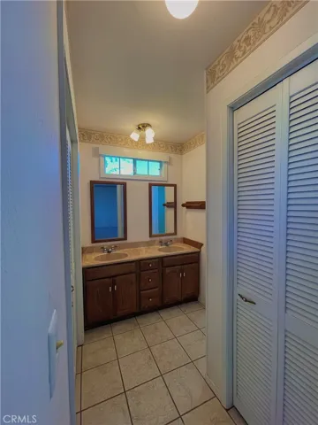 Primary Bathroom: double vanity/sinks and bi-fold closets
