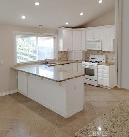 Beautiful kitchen tile flooring, granite counters, travertine backsplash, and a butler's pantry