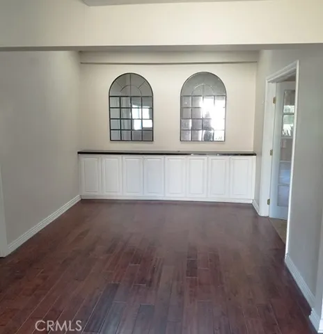 This room could be a formal dining room, home office, den, homework room, or yoga studio with a skylight, ceiling fan, and distressed dark wood floors.