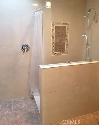 Master bathroom with dual sinks and a step in shower