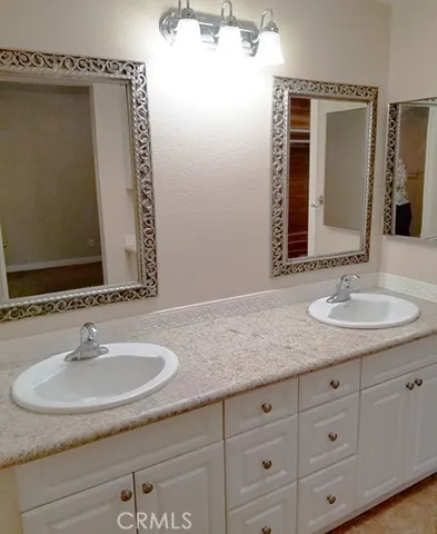 Master bathroom with dual sinks and a step in shower