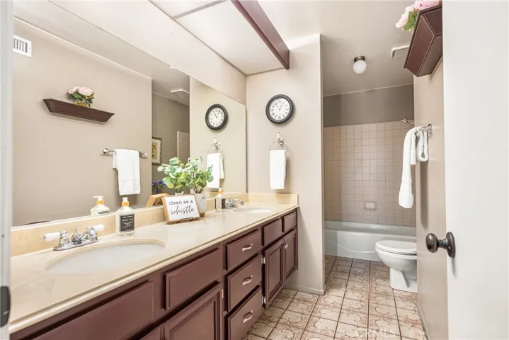 Hall bathroom with double sinks, and tub shower