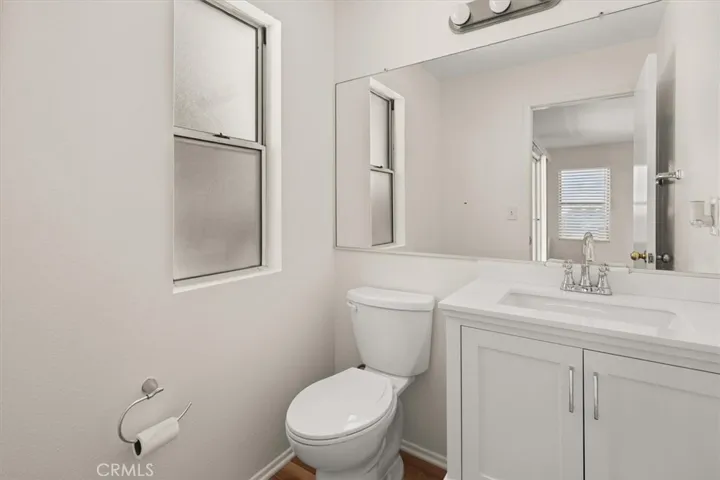 downstairs half bath with new vanity ,toilet lights and upgraded vinyl  flooring