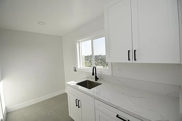 LAUNDRY ROOM WITH SINK AND CABINETS