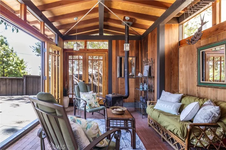 A separate structure ~ a beautiful glass enclosed Cabana is a favorite hangout spot with an additional sleeping area, complete with a wood stove and beautiful high ceiling