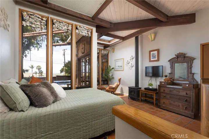 Primary bedroom with tons of light, skylight, glass doors to the patio and an attached full bathroom with access to the mud room.