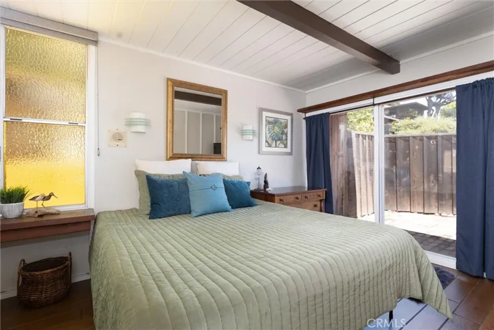 Second larger bedroom with beamed ceiling, slider door to the back patio, lots of light and storage and room for a king sized bed.