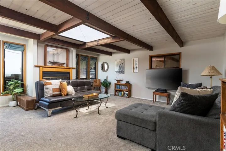 Generous family room, beamed ceiling, skylights, and a fireplace with room to be entertained and relax