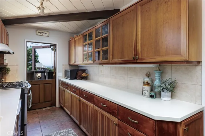 Great counter space and Dutch door to the front patio. Lots of storage, tile backsplash and gas stovetop/oven