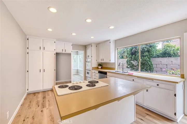 Kitchen boasts ample cabinet space and a convenient cooktop island.