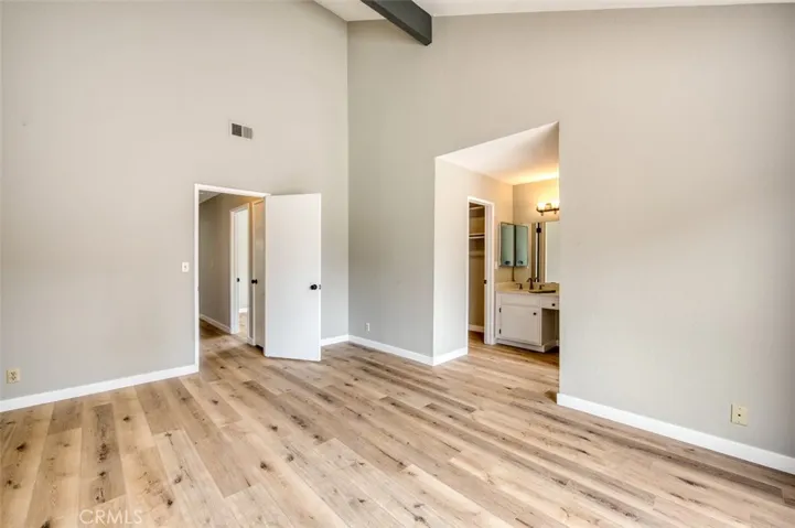 Primary bedroom with en suite bathroom, walk-in closet, and vaulted ceiling.