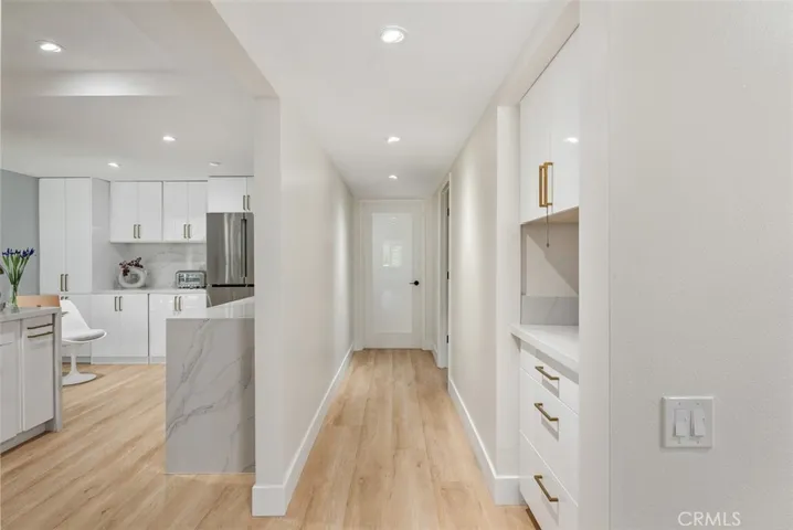 A great view of the hallway and kitchen facing the primary bedroom and Br 2