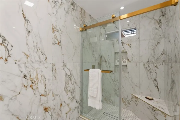Primary Shower with seating bench, toiletry nook and linear drain