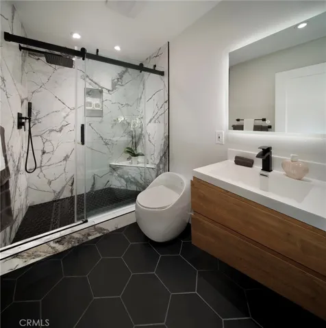 Beautiful and chic guest bathroom with custom tile flooring, fixtures and porcelain shower