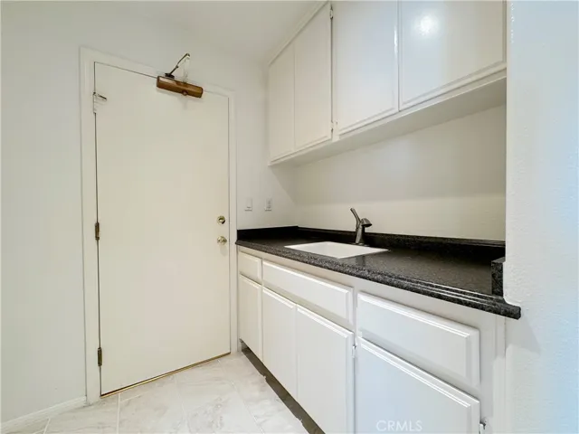 Indoor laundry with sink and storage
