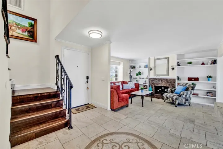 Dramatic Tumbled Marble Foyer with Inlay. Hardwood Staircase, Formal Living Room with Fireplace and Custom Built-In Shelving