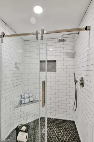 Walk-In Shower with Sitting Bench, Shampoo Niche, Multiple Shower Heads, Subway Tile Surround and Barn Door Clear Glass Enclosure