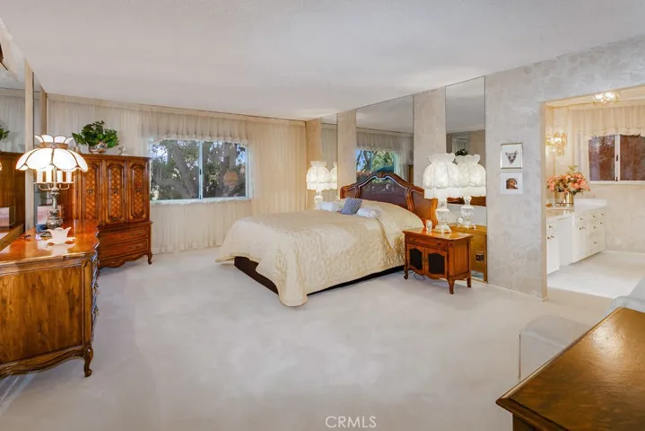 The generously sized primary suite is drenched in natural light from a glistening window and is enriched with plush wall-to-wall carpet and a huge cedar-lined walk-in closet with built-in organizers and closet island.