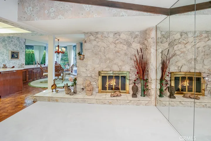 The formal dining room with its rich wood-beamed ceilings, raised hearth floor-to-ceiling sugar marble fireplace, mirrored wall and wall-to-wall plush carpet, it is perfect for any occasion.