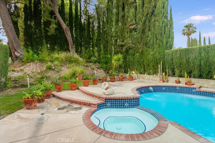 The secluded backyard will be a favorite entertainment destination with its sparkling in-ground heated fiberglass lined pool and spa, new pool light, grassy areas, shaded open patio, towering privacy and shade trees, colorful flowerbeds, remote controlled electric awnings that shades the house, handy garden shed, PLUS a convenient poolside outdoor bathroom with vanity, dressing mirror, storage shelves, commode and tiled floors.